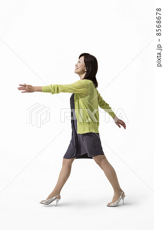 手を振って歩く中高年女性の写真素材