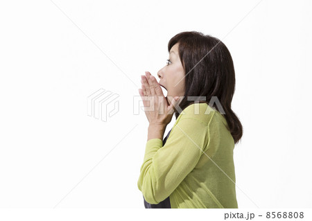 口に手をあてる中高年女性の写真素材