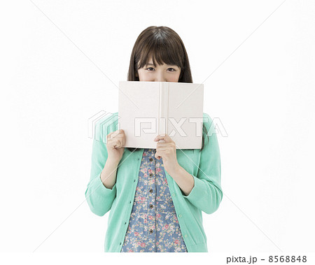本で顔を隠す女性の写真素材