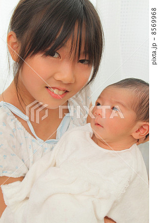 赤ちゃんを抱っこする小学生 8569968