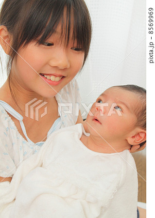 赤ちゃんを抱っこする小学生 8569969