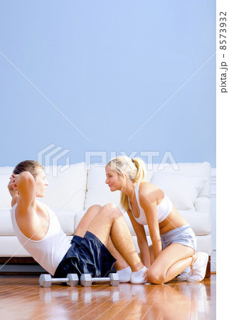 Couple Exercising on Living Room Floor Couple Exercising on Living Room Floor 8573932