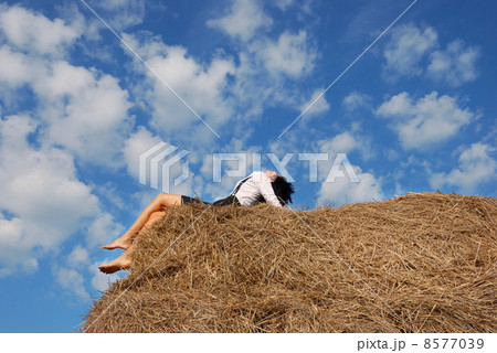 Woman on hay bale in summer field Woman on hay bale in summer field 8577039