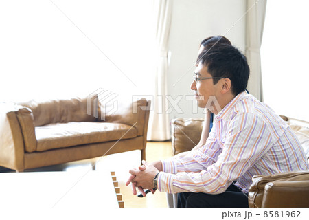 リビングでテレビを見ながらリラックスする夫婦 8581962