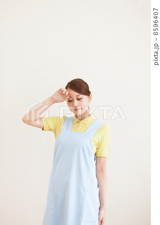 おでこを触る看護師 8596407