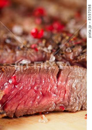 Beef steak on a wooden board and table Beef steak on a wooden board and table 8597098