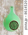 green peppercorns in bowl on green wooden board 8614520