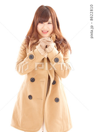暖かそうなコートを着て胸の前で手を組むキュートな女性 8622810