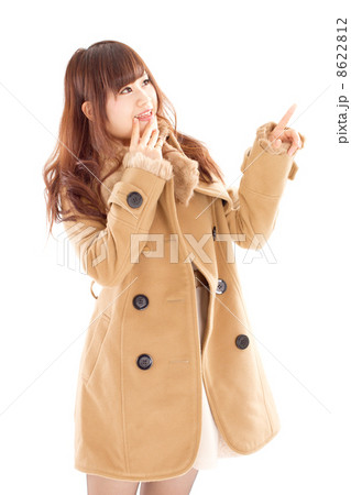 暖かそうな厚手のコートを着て楽しそうに斜め上を指さす女性 8622812