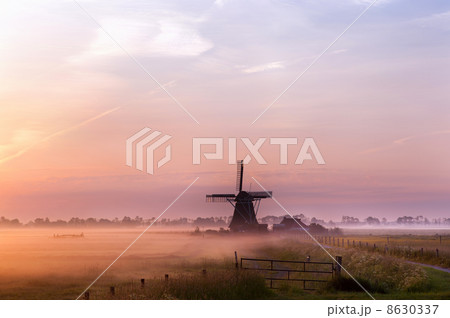 Dutch windmill in fog in the early morning 8630337