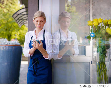 Young woman working as florist in shop and text messaging Young woman working as florist in shop and text messaging 8633165