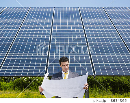 businessman standing near solar panels businessman standing near solar panels 8634366