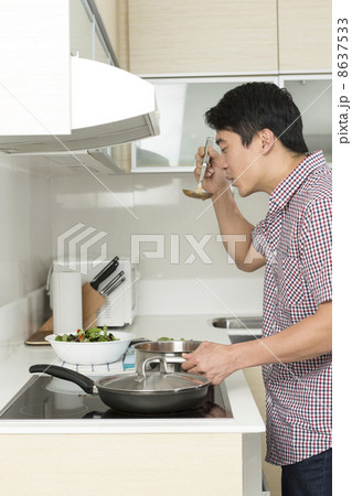 Asian man in kitchen making food for dinner. 8637533