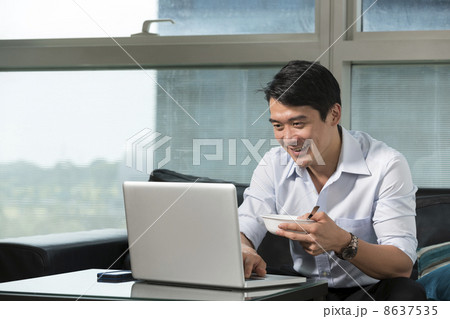 Asian business man working on a laptop Asian business man working on a laptop 8637535