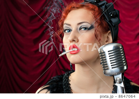 beautiful redhead woman smoking cigarette near vintage microphone 8647064