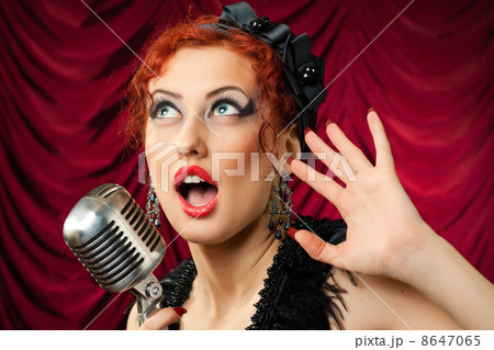 beautiful redhead woman singing into vintage microphone 8647065