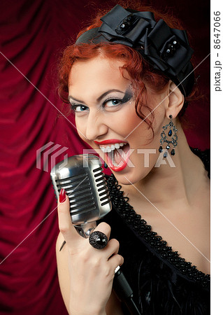 beautiful redhead woman singing into vintage microphone 8647066