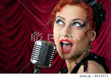 beautiful redhead woman singing into vintage microphone 8647072