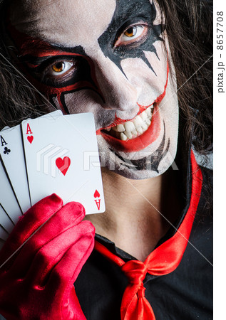 Evil clown with cards in dark room Evil clown with cards in dark room 8657708
