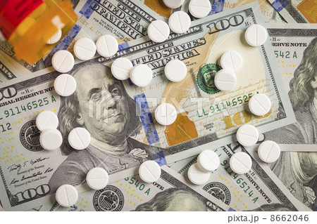 Medicine Pills Scattered on Newly Designed One Hundred Dollar Bi 8662046