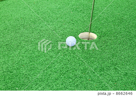 golf ball on lip of cup 8662646