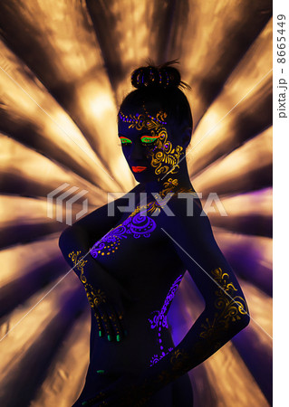 Portrait of attractive naked woman with UV makeup 8665449