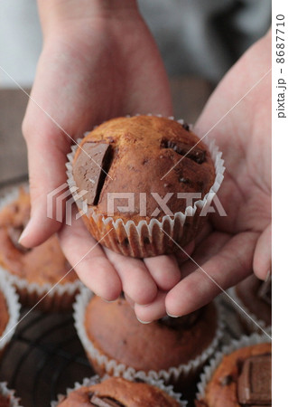 手作りのチョコマフィンを両手で持つ女性の手 8687710