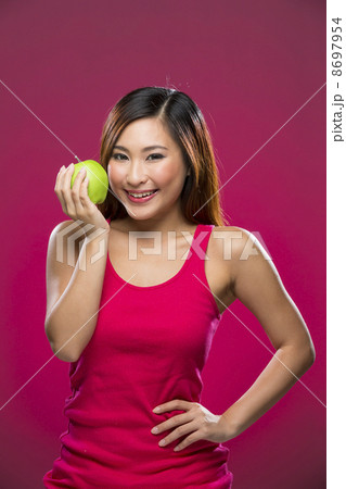 Happy Chinese Woman holding an apple on pink background. Happy Chinese Woman holding an apple on pink background. 8697954