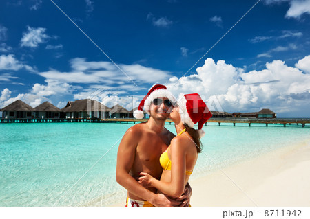 Couple in santa's hat on a beach at Maldives 8711942