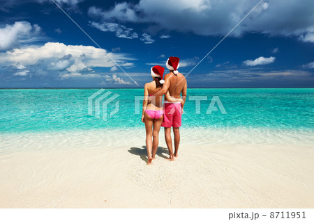 Couple in santa's hat on a beach at Maldives Couple in santa's hat on a beach at Maldives 8711951