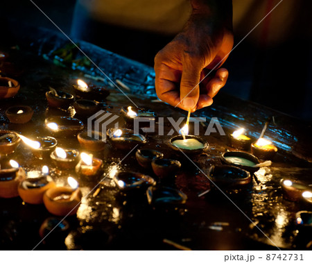 People burning oil lamps as religious ritual in Hindu temple. In 8742731