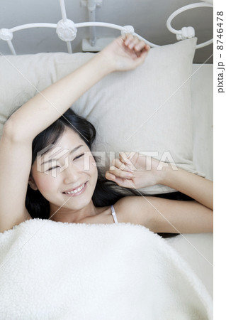 ベッドでリラックスする女性 8746478