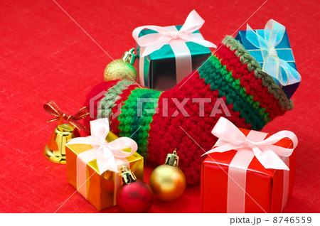 赤い布の上のクリスマスプレゼントと靴下 8746559