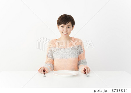 食事の席に着く女性の写真素材