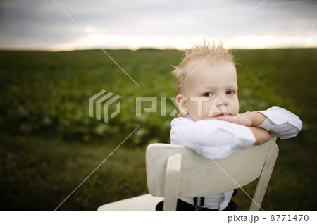 boy sits on chair in the field 8771470