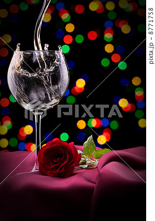 glass of wine and rose on black 8771758