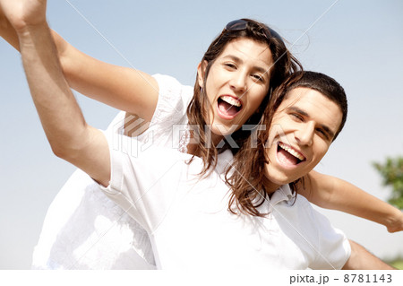Smiling young couple holding hands eachother while piggyback Smiling young couple holding hands eachother while piggyback 8781143