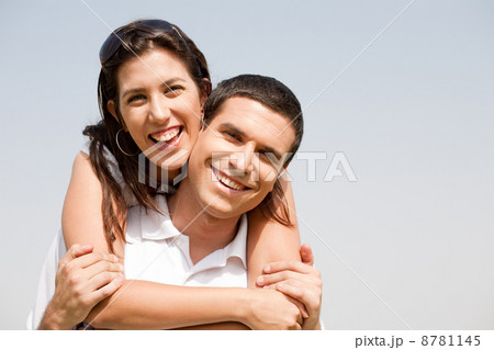Happy young guy piggybacking his girlfriend Happy young guy piggybacking his girlfriend 8781145