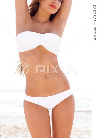 woman on the beach wearing white bikini woman on the beach wearing white bikini 8782373
