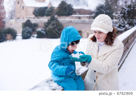Mother and toddler boy having fun with snow on winter day Mother and toddler boy having fun with snow on winter day 8782909