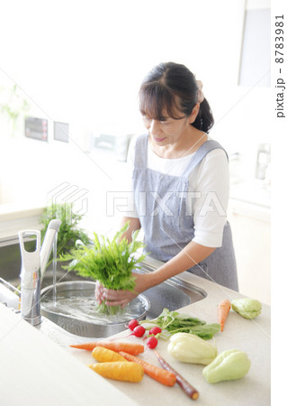 キッチンで野菜を洗う主婦 8783981
