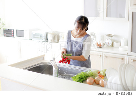 キッチンで野菜を洗う主婦 8783982