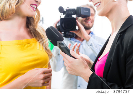 Reporter and cameraman shoot an interview 8794757