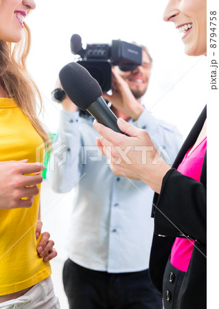 Reporter and cameraman shoot an interview 8794758