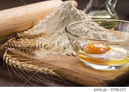 Baking ingredients with wheat ears on wood board 8796167