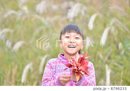 紅葉した葉を持って笑う女の子 8796233