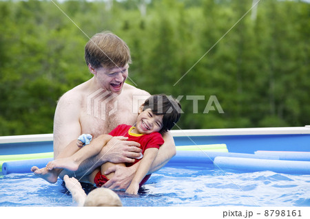 Father holding disabled son in pool 8798161