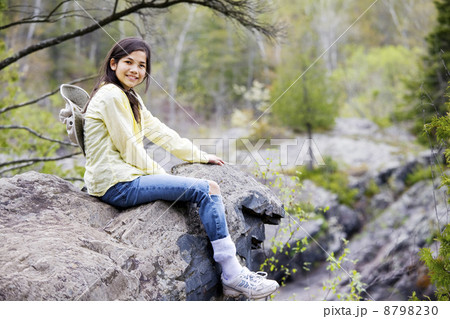 Girl sitting on rock cliff edge Girl sitting on rock cliff edge 8798230