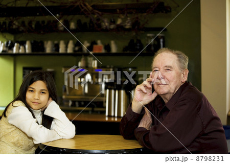 Elderly man and granddaughter at coffee shop restaurant together Elderly man and granddaughter at coffee shop restaurant together 8798231