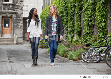 Young female friends having a chat while walking 8800599